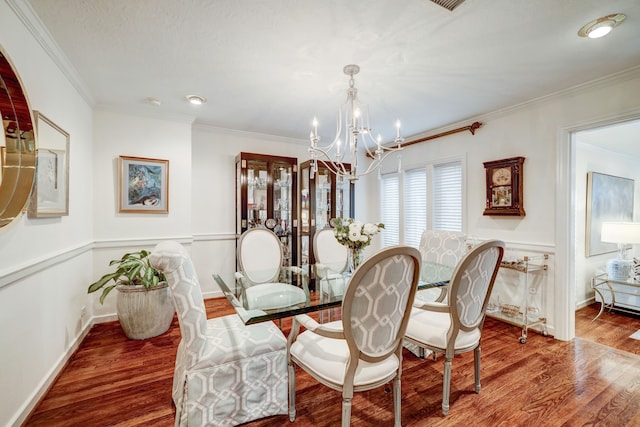 dining room with a chandelier, wood-type flooring, and crown molding