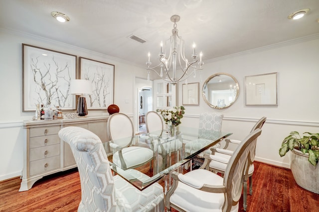 dining area with a chandelier, crown molding, and wood-type flooring