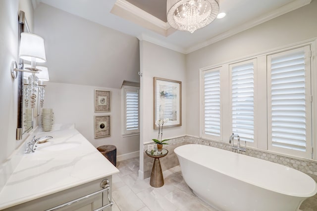 bathroom with a notable chandelier, a bathtub, ornamental molding, and vanity