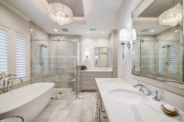 bathroom with vanity, separate shower and tub, a tray ceiling, and a chandelier