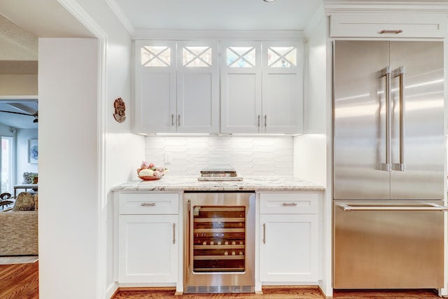 bar featuring white cabinetry, wine cooler, and built in fridge