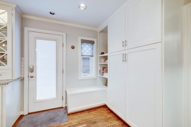 doorway to outside with light hardwood / wood-style floors and crown molding