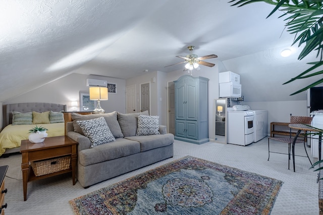 carpeted living room featuring an AC wall unit, ceiling fan, washer and clothes dryer, and lofted ceiling