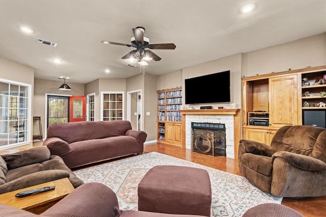 living room with light hardwood / wood-style floors and ceiling fan