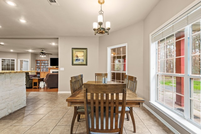 dining room with light tile flooring and ceiling fan with notable chandelier