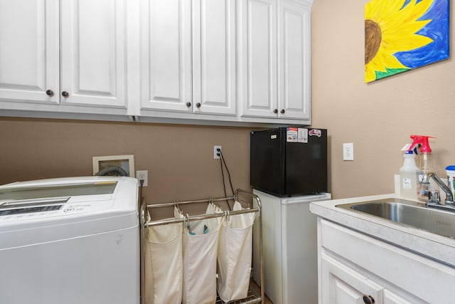 laundry room with cabinets, washer / dryer, and sink