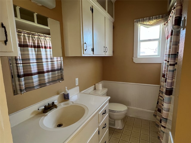 bathroom with tile flooring, large vanity, and toilet