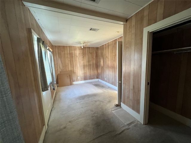 interior space featuring wood walls, light carpet, and a closet