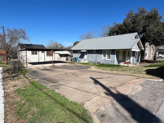 ranch-style home featuring a porch, a carport, and a front yard