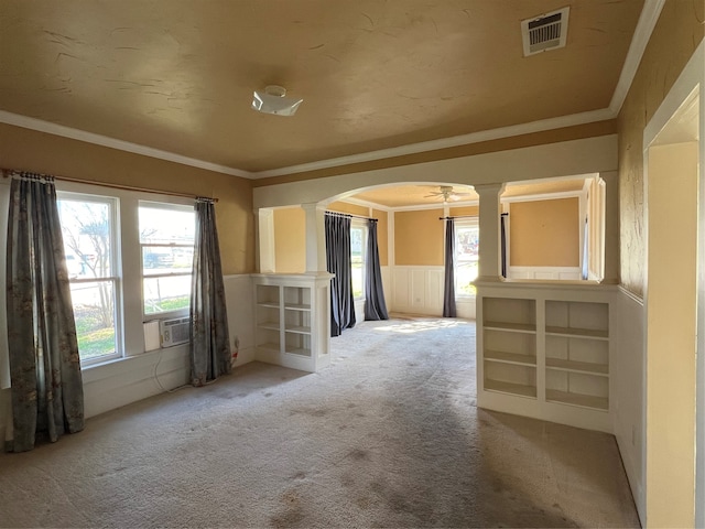 carpeted empty room with crown molding and built in features