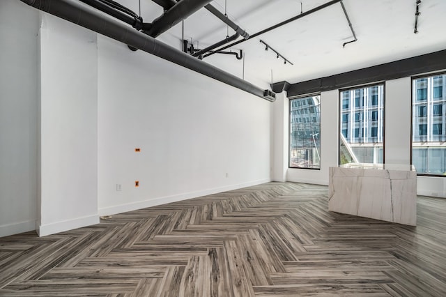 spare room featuring track lighting and parquet flooring