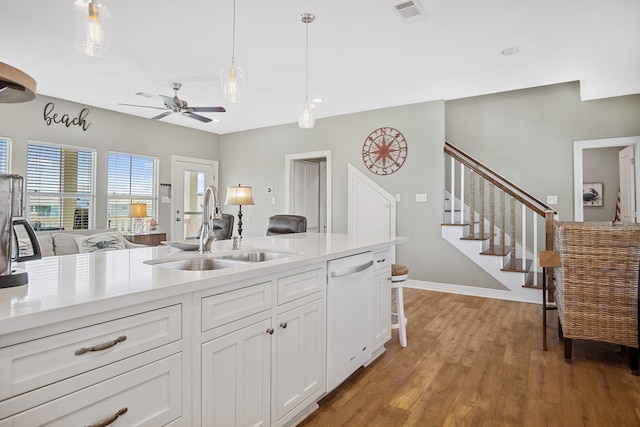 kitchen with decorative light fixtures, light hardwood / wood-style floors, ceiling fan, sink, and white dishwasher