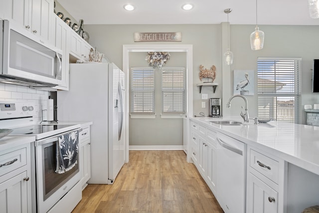 kitchen featuring electric range, white dishwasher, backsplash, light hardwood / wood-style floors, and decorative light fixtures