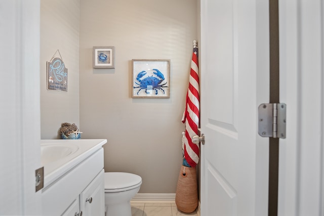 bathroom with toilet, vanity, and tile flooring