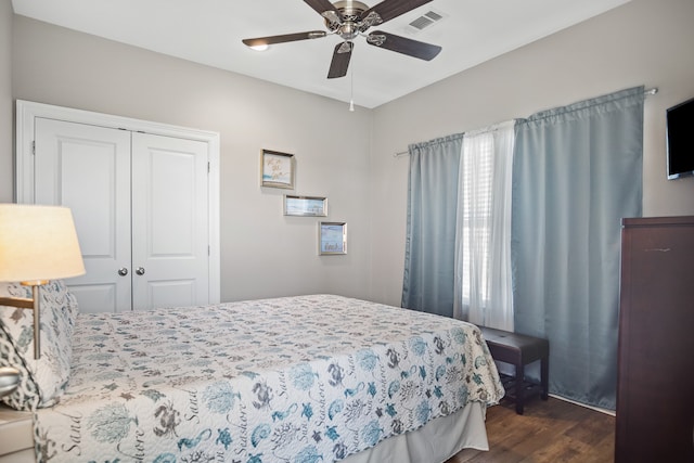 bedroom with ceiling fan, a closet, and dark wood-type flooring