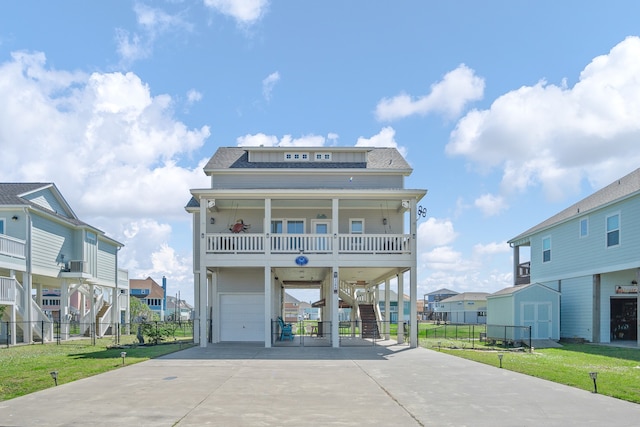 view of front of house featuring a front lawn, a balcony, a garage, and a storage shed