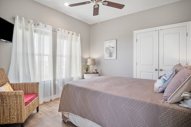 bedroom featuring ceiling fan, a closet, and light wood-type flooring