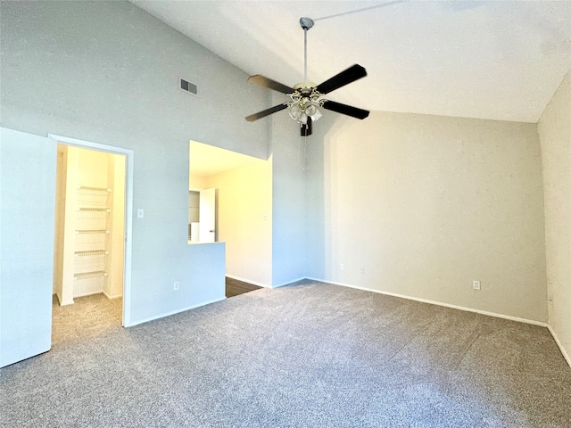 carpeted empty room with ceiling fan and high vaulted ceiling