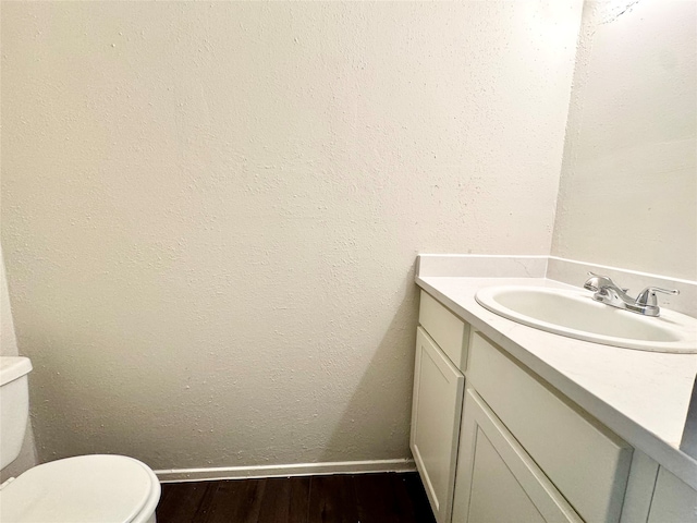 bathroom featuring vanity, wood-type flooring, and toilet