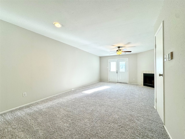 interior space featuring ceiling fan, a tile fireplace, and light carpet