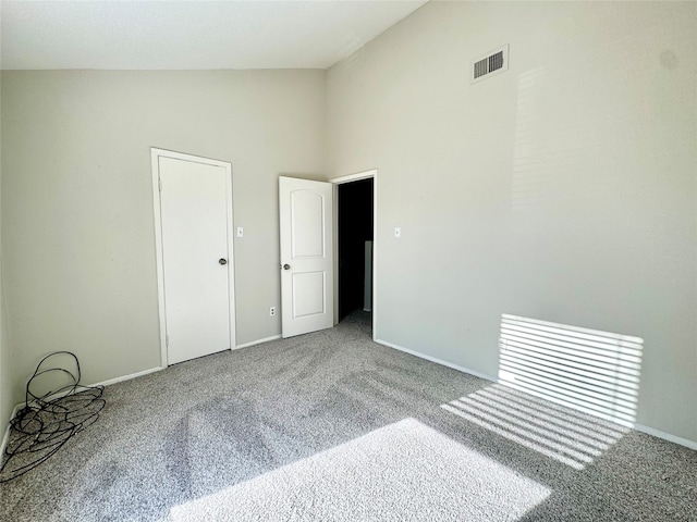 spare room with light colored carpet and high vaulted ceiling