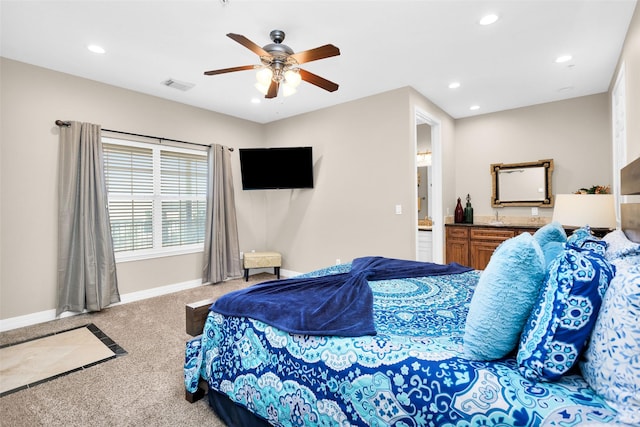 bedroom with ceiling fan, connected bathroom, and carpet flooring