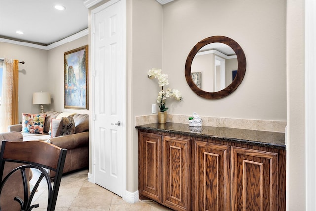 bathroom featuring tile patterned flooring, vanity, and crown molding