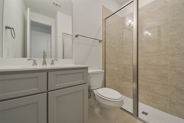 bathroom featuring vanity, toilet, tile patterned floors, and a shower with shower door