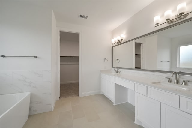 bathroom featuring tile walls, tile patterned flooring, vanity, and a tub