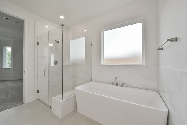 bathroom featuring shower with separate bathtub and tile patterned flooring