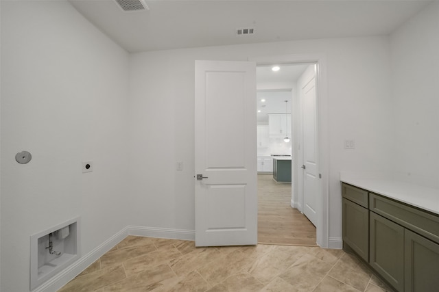 laundry area featuring cabinets, hookup for an electric dryer, and light hardwood / wood-style floors