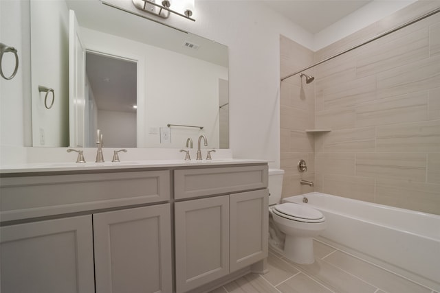 full bathroom featuring tile patterned floors, tiled shower / bath combo, vanity, and toilet