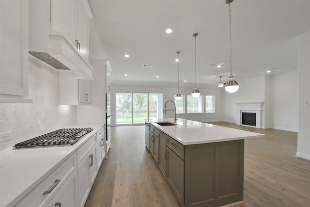 kitchen featuring white cabinetry, sink, stainless steel appliances, and a large island