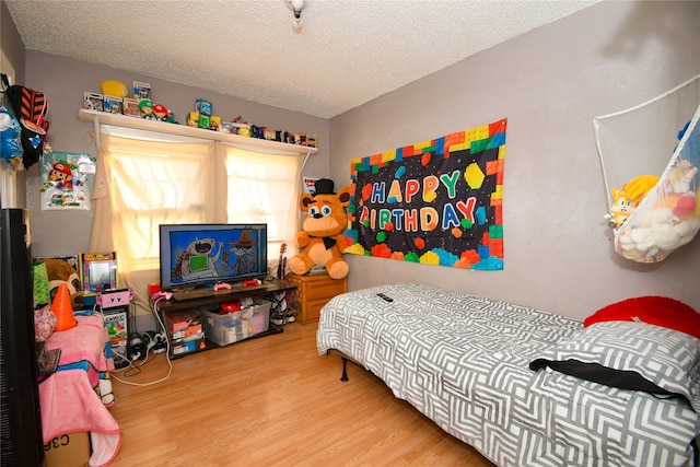 bedroom with hardwood / wood-style flooring and a textured ceiling