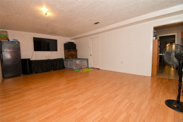 interior space with light hardwood / wood-style floors and a textured ceiling