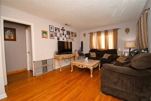 living room with a textured ceiling and hardwood / wood-style flooring