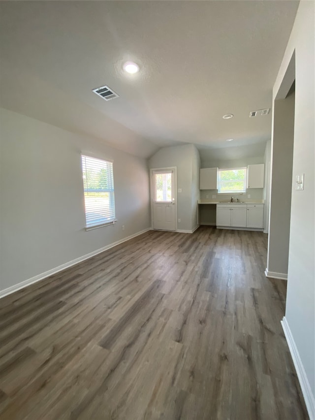unfurnished living room with baseboards, dark wood-style floors, vaulted ceiling, and recessed lighting
