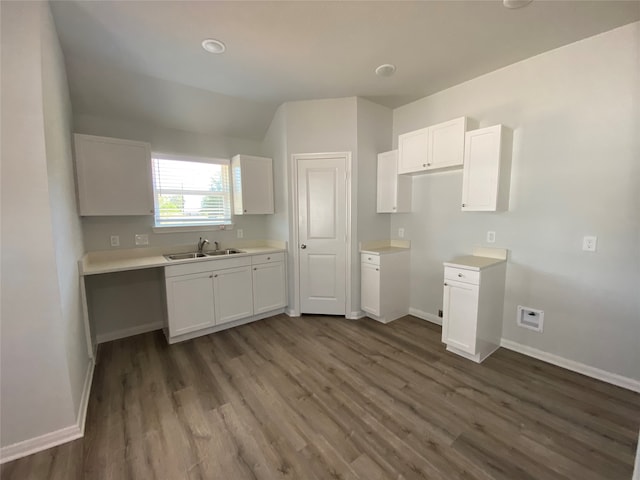 kitchen featuring a sink, dark wood-style flooring, baseboards, and white cabinetry
