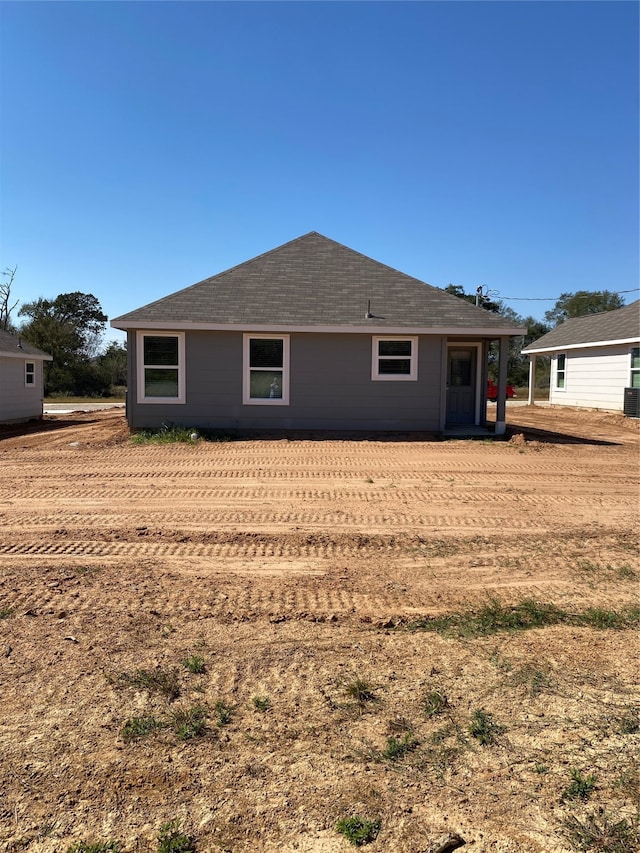 rear view of property with roof with shingles