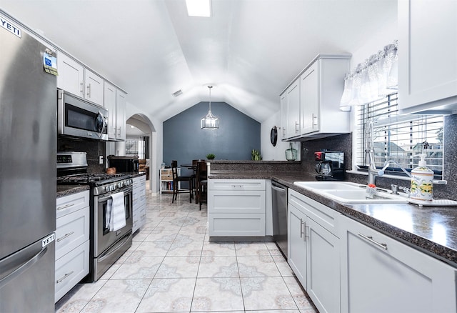 kitchen with pendant lighting, tasteful backsplash, appliances with stainless steel finishes, and white cabinetry