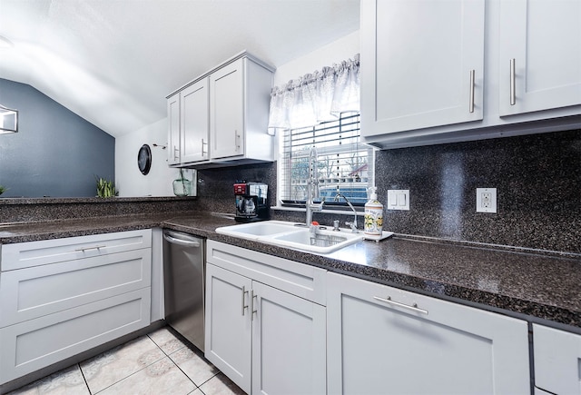 kitchen featuring tasteful backsplash, white cabinets, light tile floors, sink, and vaulted ceiling