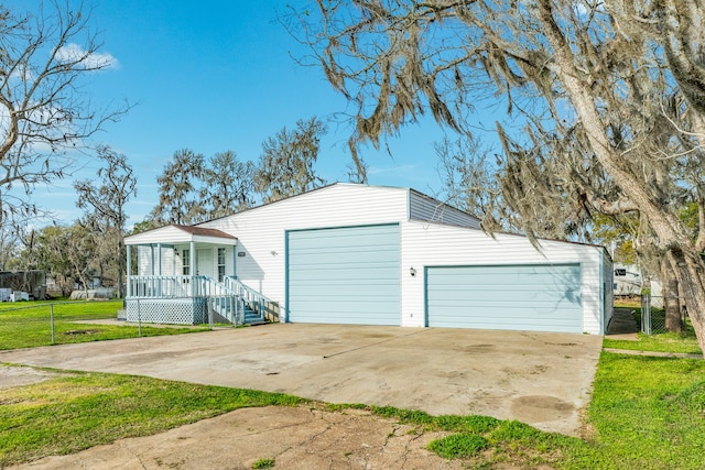 garage featuring covered porch and a yard