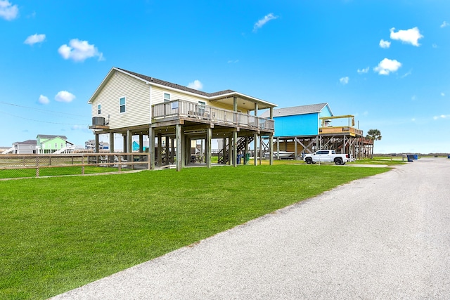 back of house featuring a wooden deck, a balcony, and a yard