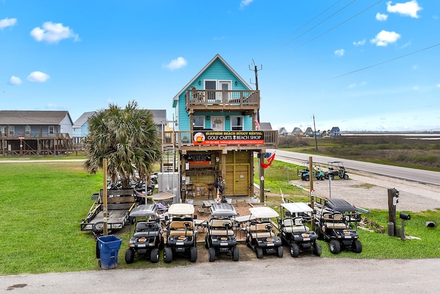 back of property with a balcony and a yard