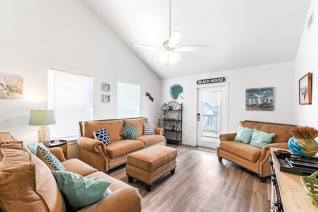 living room with ceiling fan, light hardwood / wood-style flooring, and high vaulted ceiling