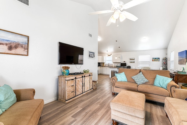 living room featuring ceiling fan, high vaulted ceiling, and light hardwood / wood-style floors