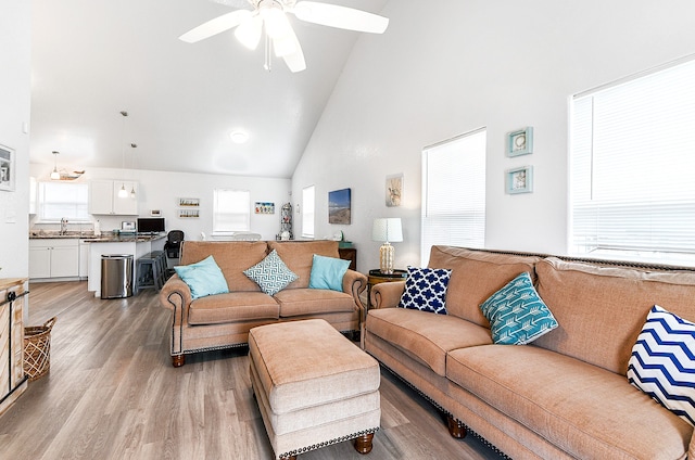 living room featuring ceiling fan, sink, high vaulted ceiling, and light hardwood / wood-style floors