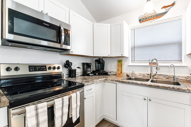 kitchen featuring appliances with stainless steel finishes, sink, lofted ceiling, and white cabinets