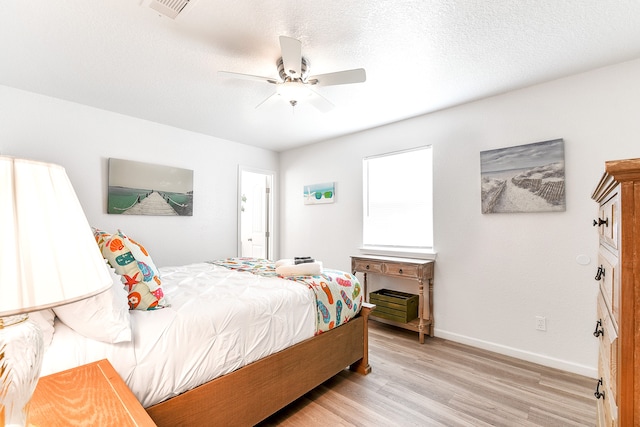 bedroom featuring a textured ceiling, light hardwood / wood-style floors, and ceiling fan