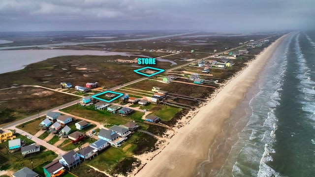 drone / aerial view with a beach view and a water view